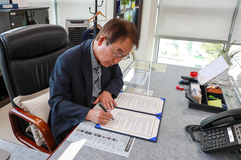 울산항만공사 변재영 사장이 사장실에서 북극항로 활성화 협력 협약서에 서명하고 있는 모습
